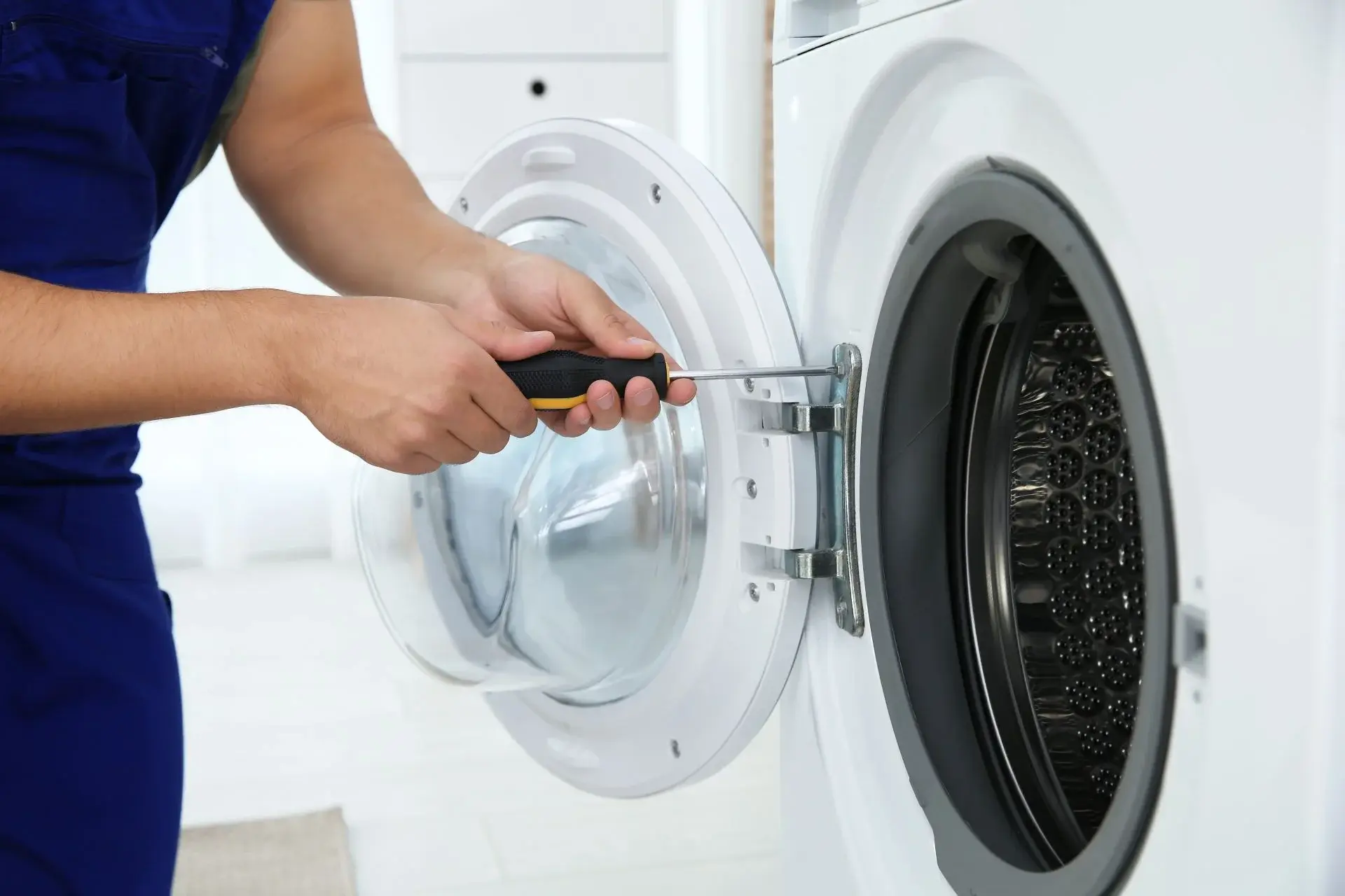 Ramson Appliances technician repairing a front-load dryer door in Groveland, FL