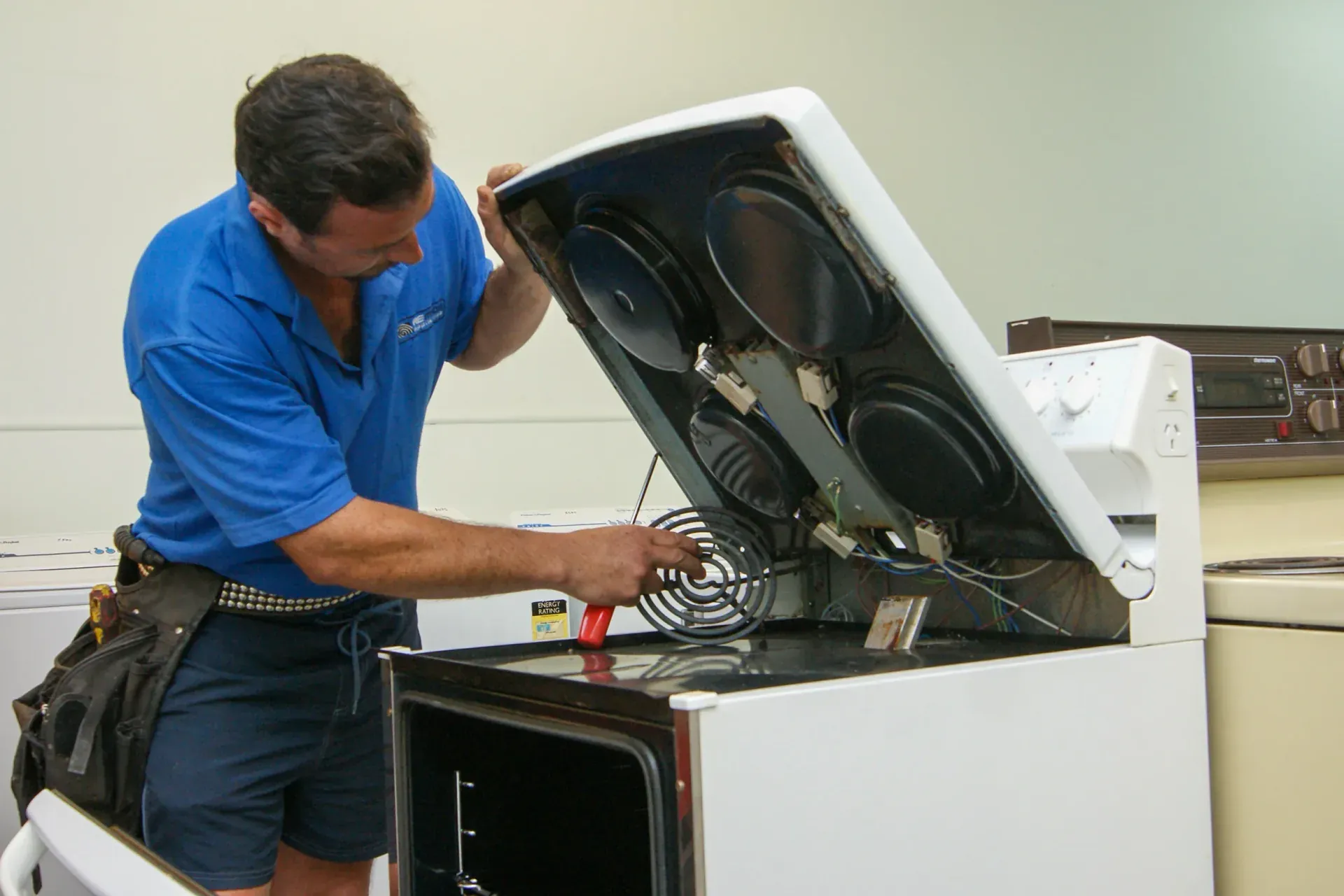 Technician checking a range on an emergency stove repair in Groveland, FL