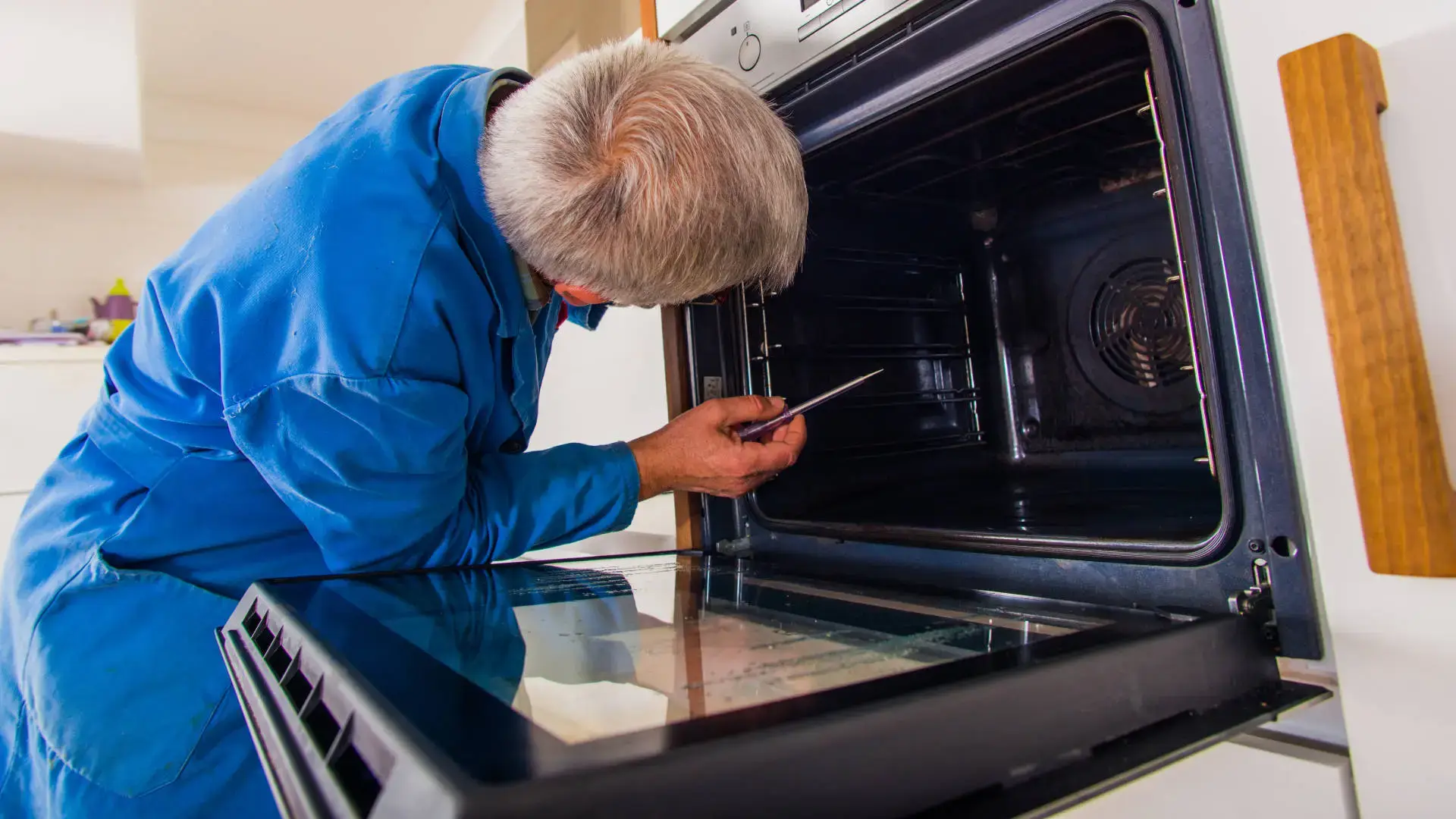 Ramson Appliances technician repairing a wall oven in a Groveland, FL kitchen