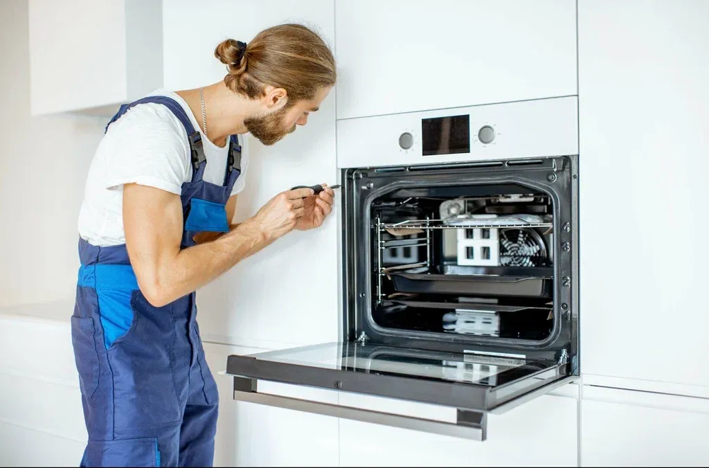 Ramson Appliances technician repairing a built-in oven door in Groveland, FL