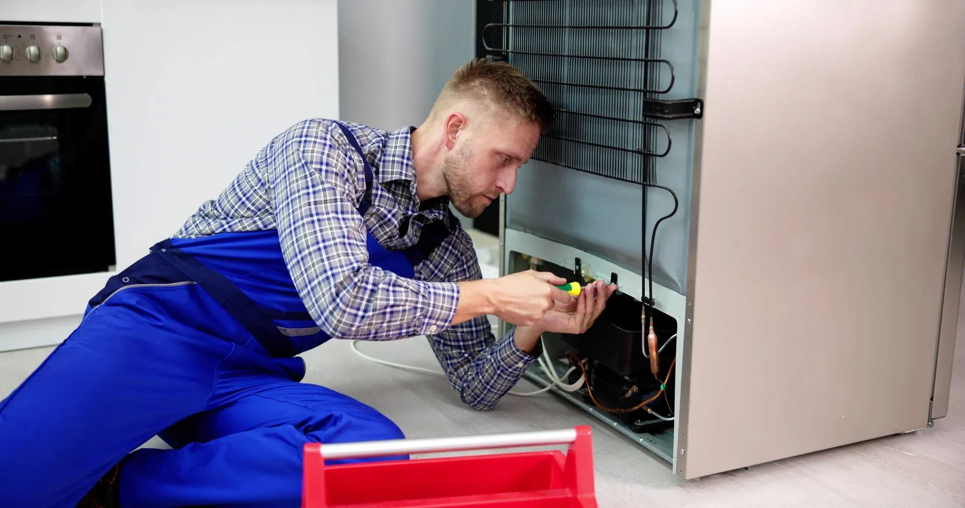 Ramson Appliances technician repairing the back of a refrigerator in Groveland, FL
