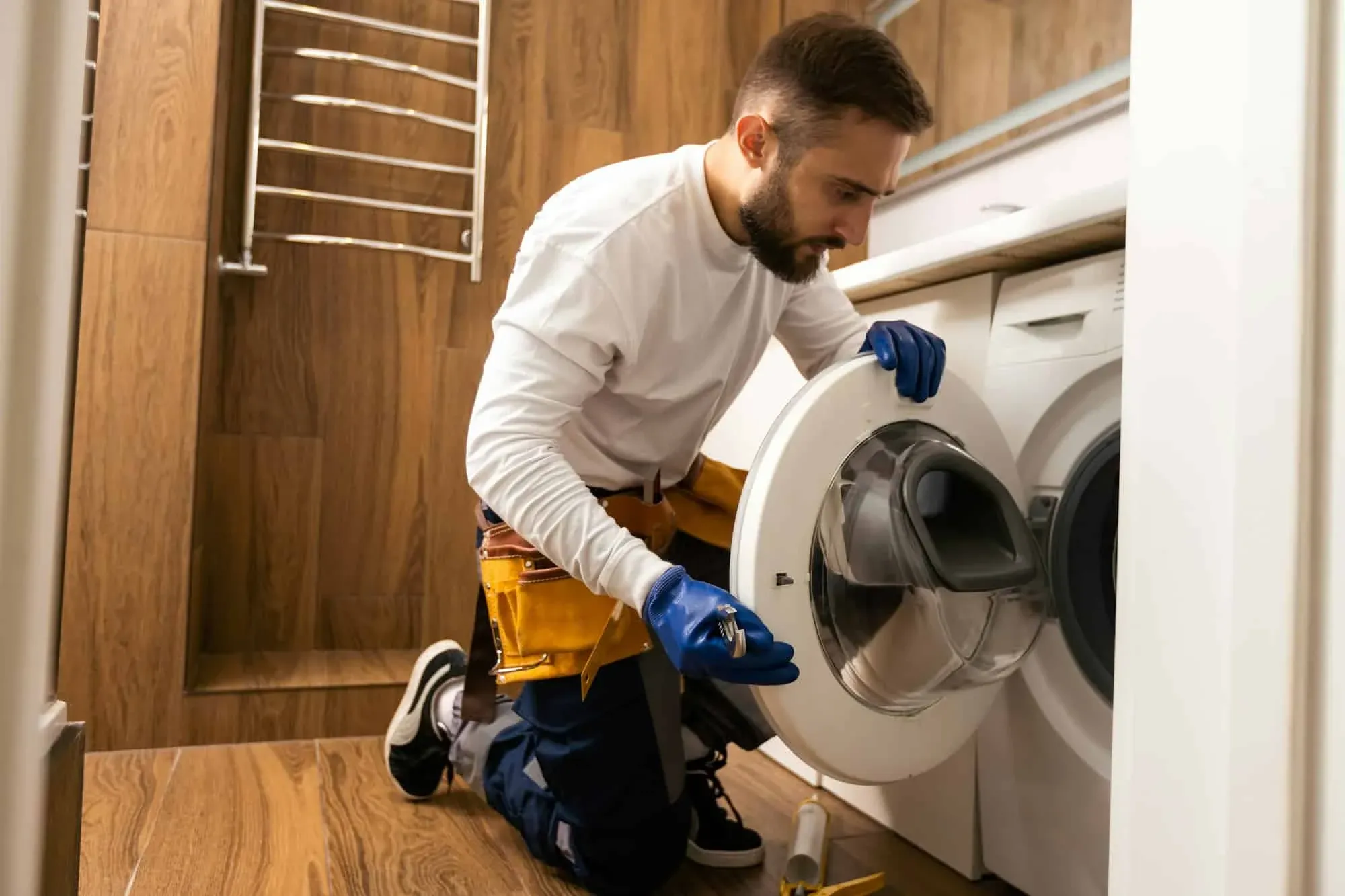 Technician fixing a washing machine door in a Groveland, FL home